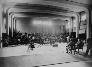 Címlapi fotó: 1935 a Magyar Rádió új 6-os stúdiójának akusztikai próbája. Háttal ül Dohnányi Ernő karmester és Békéssy György tervező. Forrása: Fortepan.hu / Rádió és Televízió Újság
