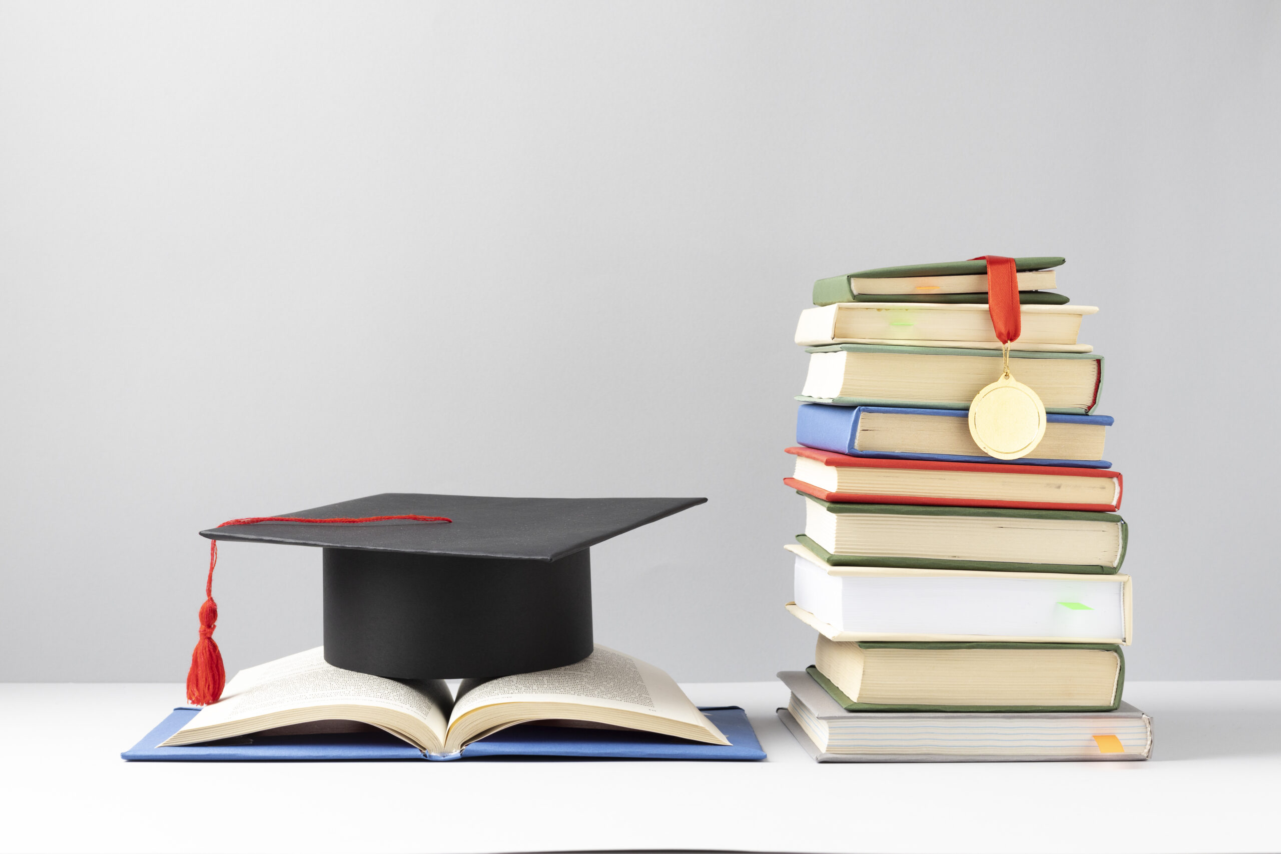 FREEPIK__front-view-stacked-books-graduation-cap-open-book-education-day