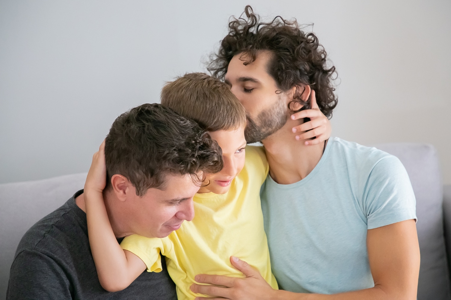 two-happy-handsome-dads-hugging-kissing-son-enjoying-leisure-time-together-happy-family-gay-parents-concept