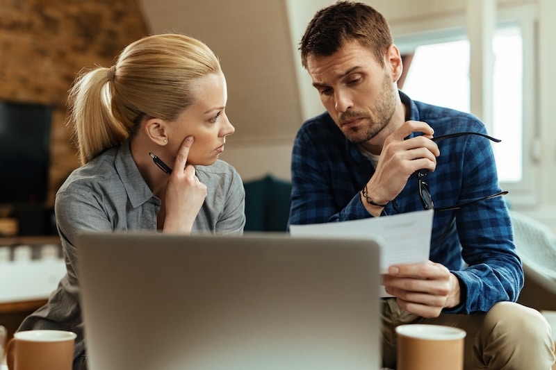 Young couple talking while analyzing their budget at home. - Freepik