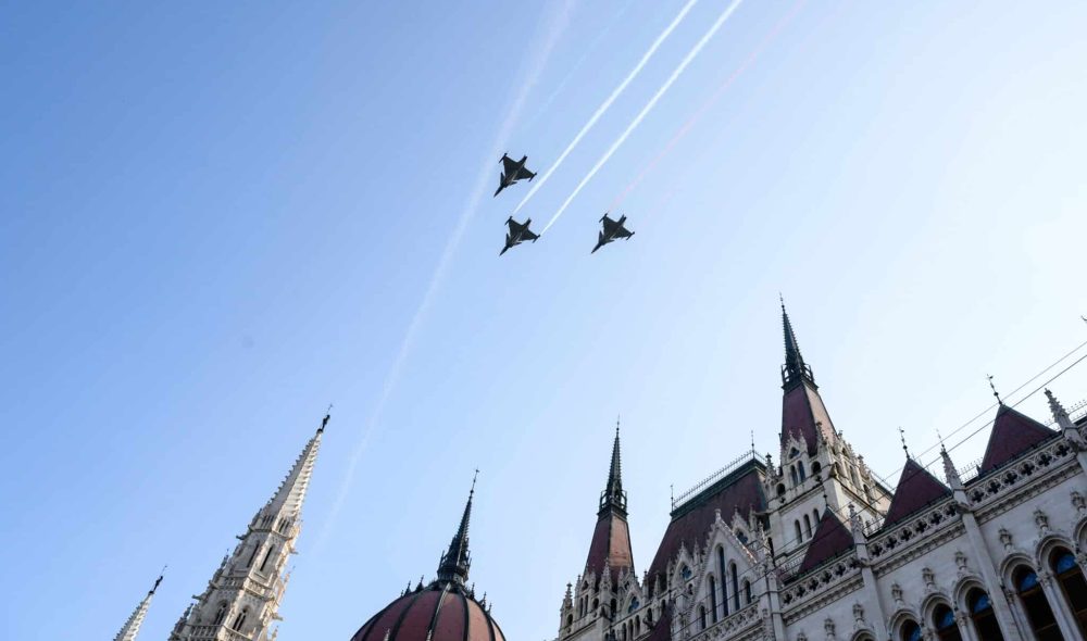 Budapest, 2024. augusztus 20.
A kecskeméti repülõdandár három Gripen harcászati repülõgépbõl álló kötelékének díszelgõ áthúzása a Kossuth tér fölött, miután az Országház elõtt felvonták a nemzeti lobogót az államalapítás és államalapító Szent István király ünnepén, 2024. augusztus 20-án.
MTI/Vasvári Tamás