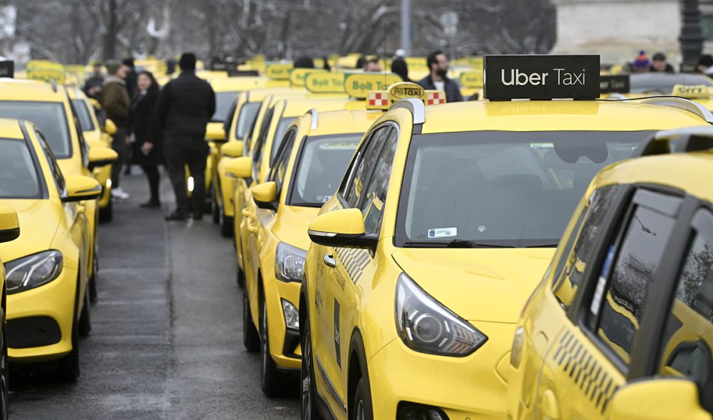 Budapest, 2025. január 15.
Taxisok gyülekezenek jarműveikkel a Hősök terén a Taxisok Érdekvédelmi Szervezetének felhívására megtartott tüntetés kezdetén, majd több csoportban az Építési és Közlekedési Minisztérium (ÉKM), a Nemzetgazdasági Minisztérium (NGM), a Pénzügyminisztérium (PM), a Főpolgármesteri Hivatal, valamint a Budapesti Közlekedési Központ (BKK) épülete elé hajtottak 2025. január 15-én.
MTI/Koszticsák Szilárd