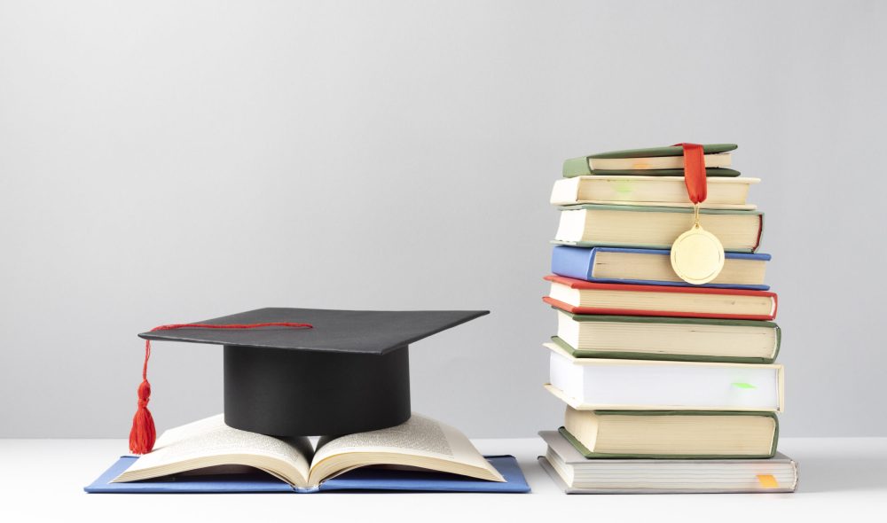 FREEPIK__front-view-stacked-books-graduation-cap-open-book-education-day