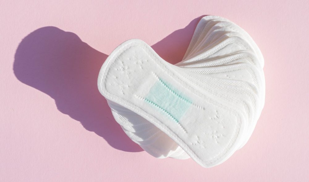 pile-daily-clean-sanitary-towels-pink-background