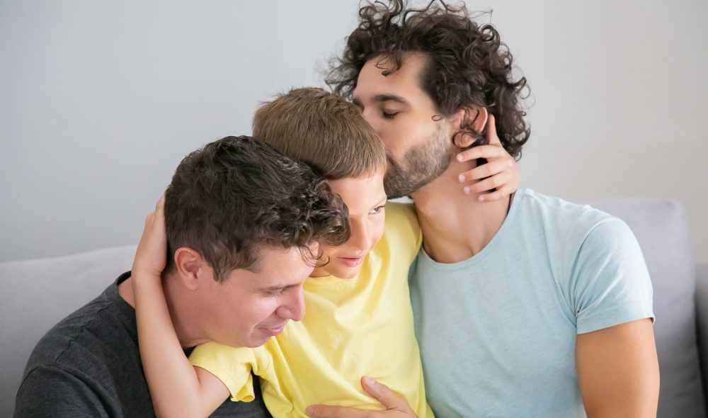 two-happy-handsome-dads-hugging-kissing-son-enjoying-leisure-time-together-happy-family-gay-parents-concept